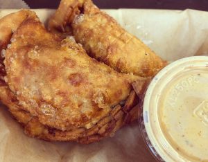 pic of fried empanadas and a container of dipping sauce